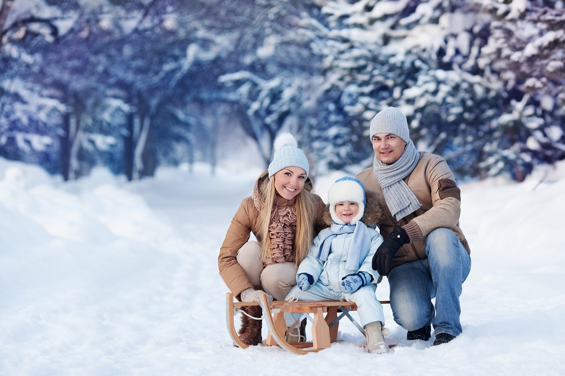 Portrait of Young family and his baby in a winter park